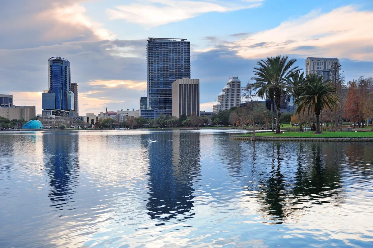 Downtown Orlando skyline and palm trees reflected in Lake Eola